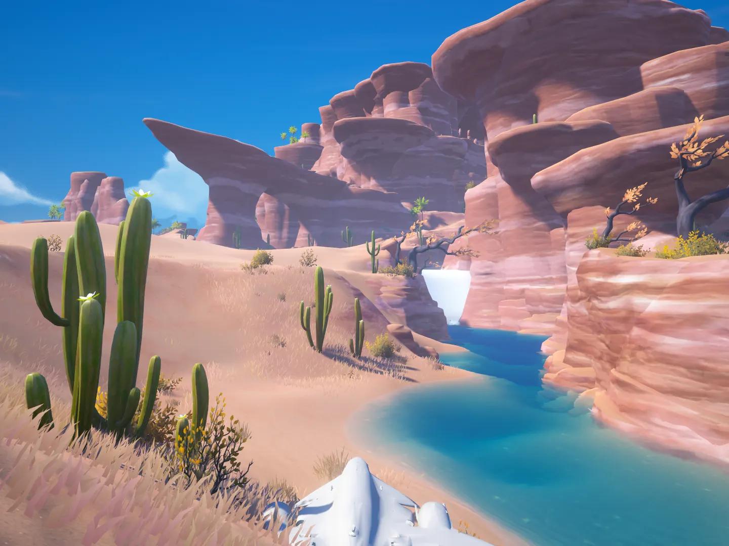 Desert oasis: a turquoise river winding between red rock canyons and cacti, with a small waterfall